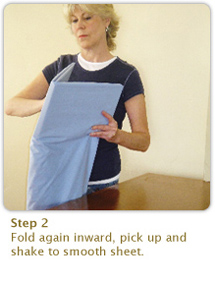 Step 2:
Fold again inward, pick up and shake to smooth sheet.